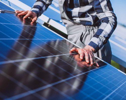 hombre-trabajador-campo-junto-paneles-solares-scaled.jpg